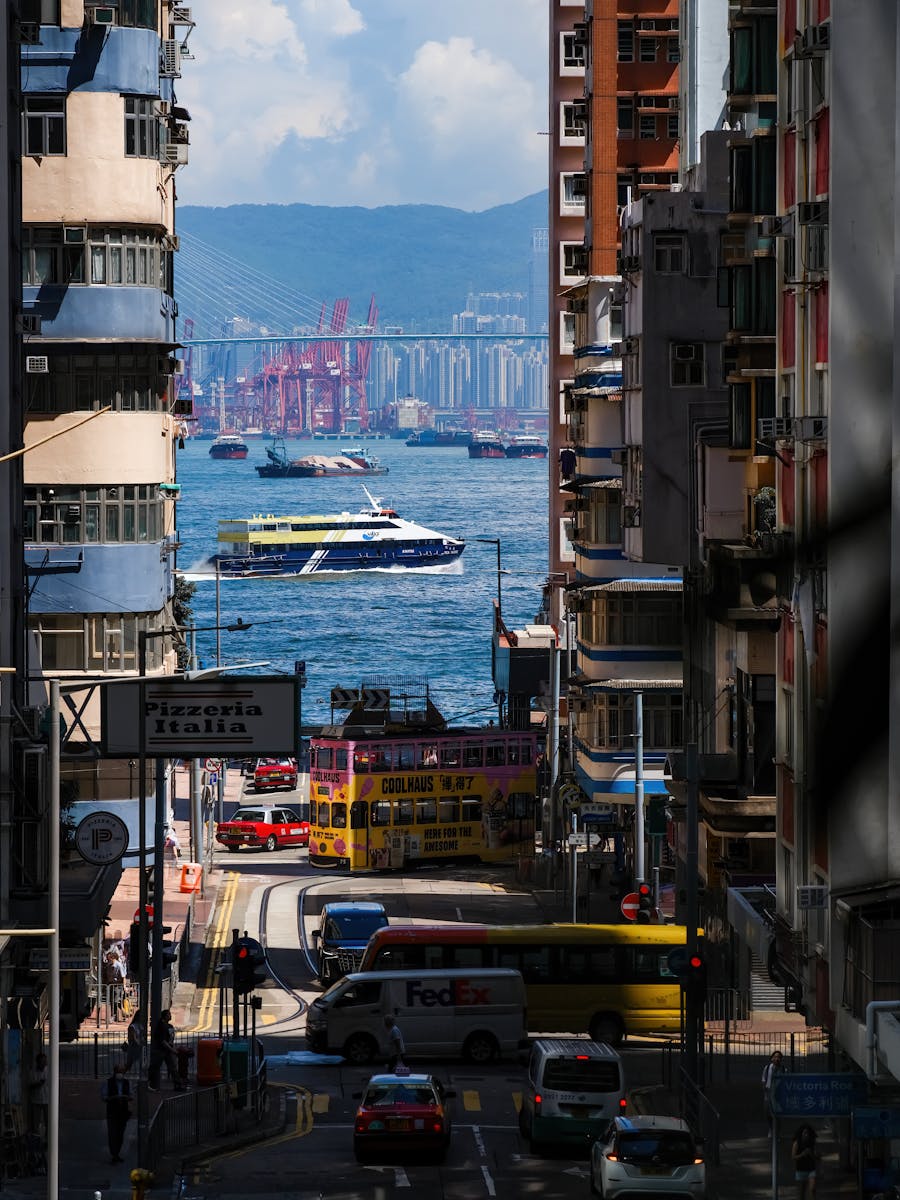 Dynamic city street with view of bustling harbor and iconic tram, featuring skyscrapers and vibrant colors.